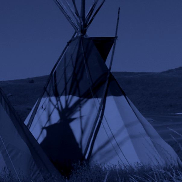 a traditional tepee standing among other tepees in the plains, the color of the photo shifted to a dark grayish blue